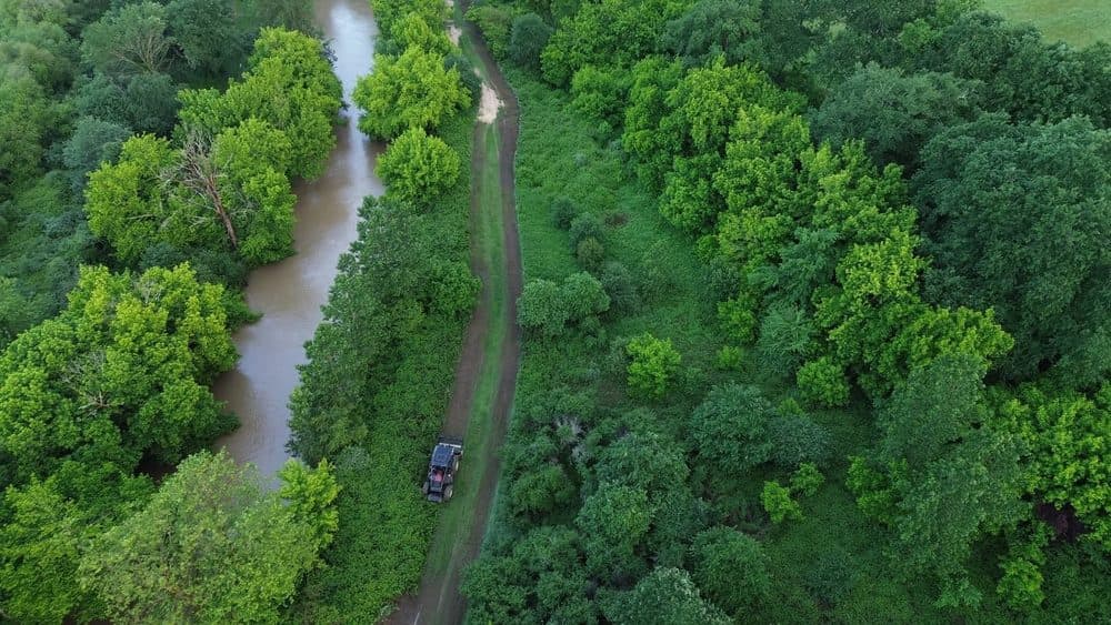 Vue aérienne du chantier de débroussaillage forestier le long d'un cours d'eau à Saint-Yaguen