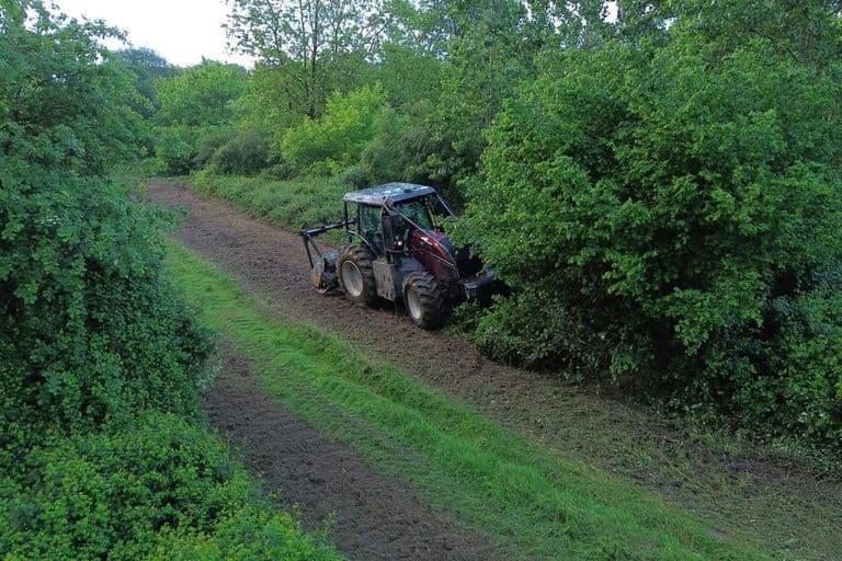 Tracteur forestier en action broyant la végétation sur un sentier à Saint-Yaguen dans les Landes