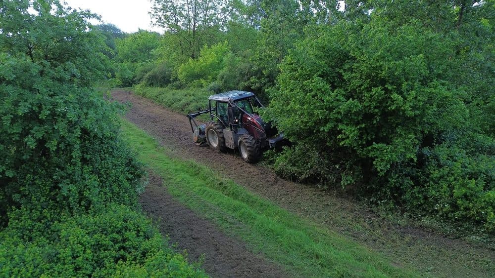 Tracteur forestier en action broyant la végétation sur un sentier à Saint-Yaguen dans les Landes