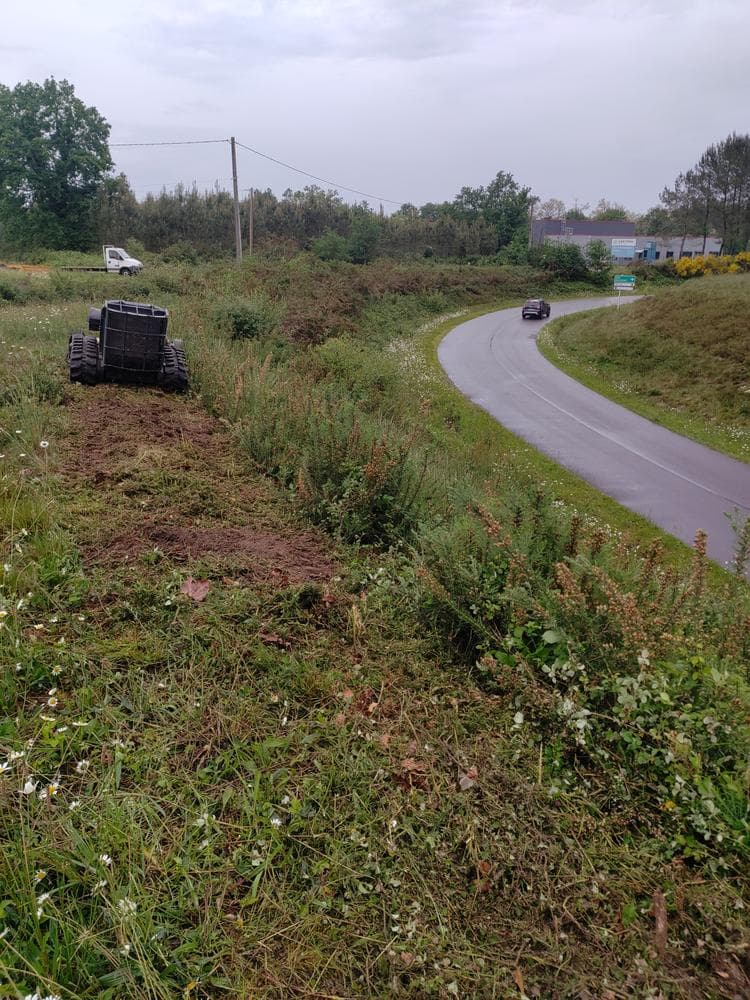 Robot chenillé débroussaillant un talus en bord de route à Carcarès-Sainte-Croix